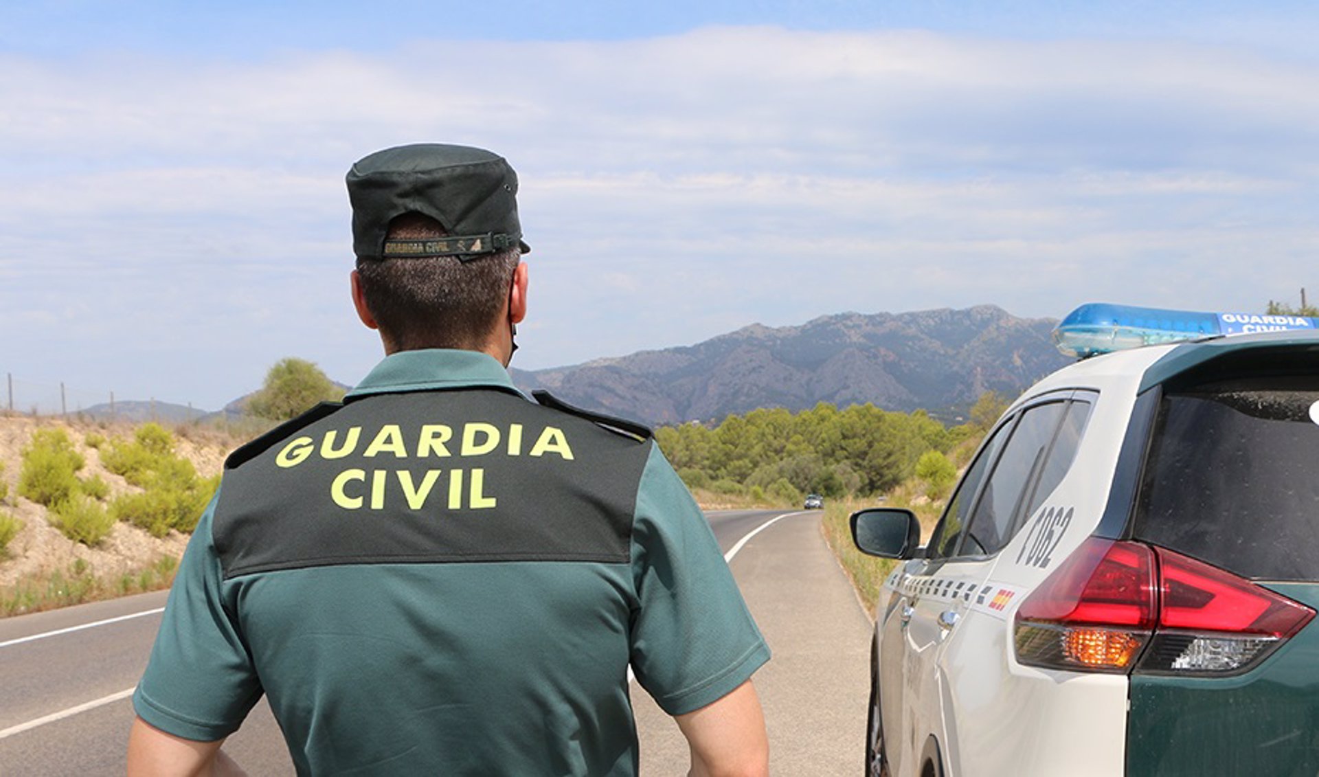 16/07/2022 Un agente de la Guardia Civil junto a un vehículo en una carretera. (Foto de archivo). SOCIEDAD GUARDIA CIVIL
