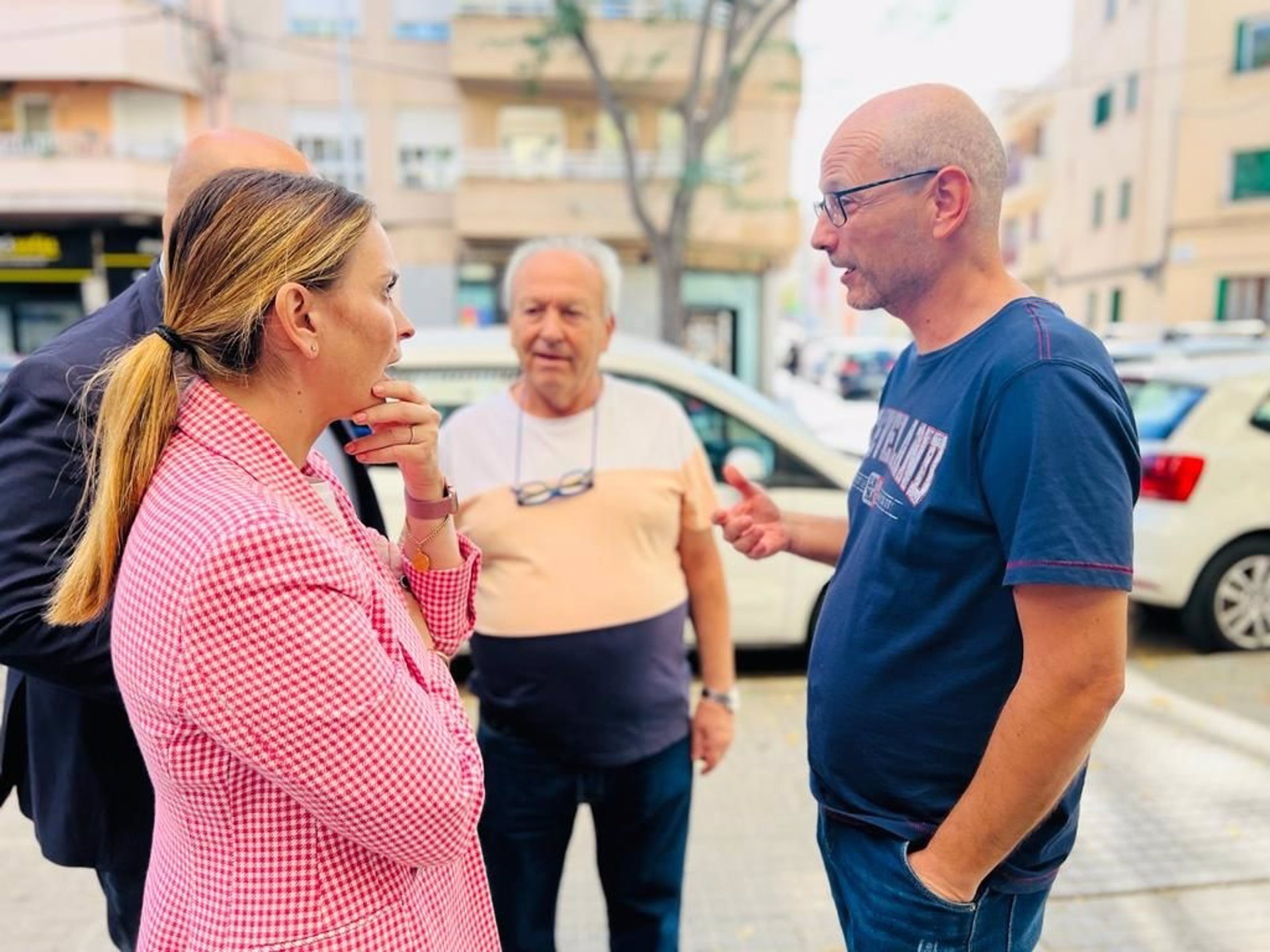 La presidenta del PP, Margalida Prohens, conversa con vecinos ante la sucursal okupada de la avenida San Fernando. - PP