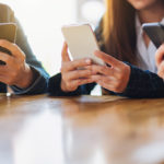 Varios usuarios consultan sus teléfonos móviles.