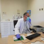 Sanitario atendiendo a un paciente por teléfono en su consulta.