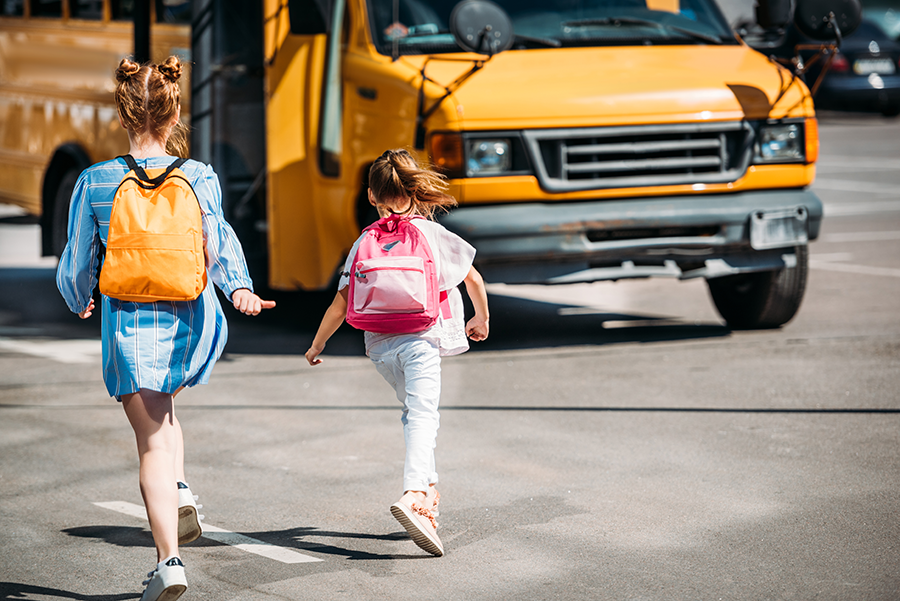 Dos alumnas se dirigen al autobús escolar.