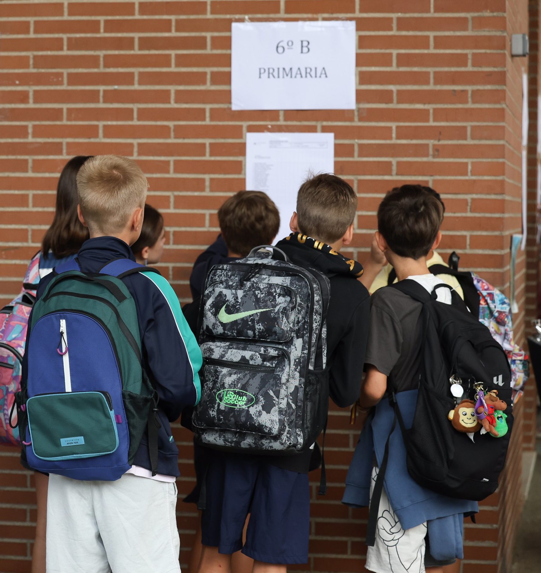 Varios alumnos con mochilas ven donde está su aula en el patio del colegio. - Marta Fernández Jara - Europa Press