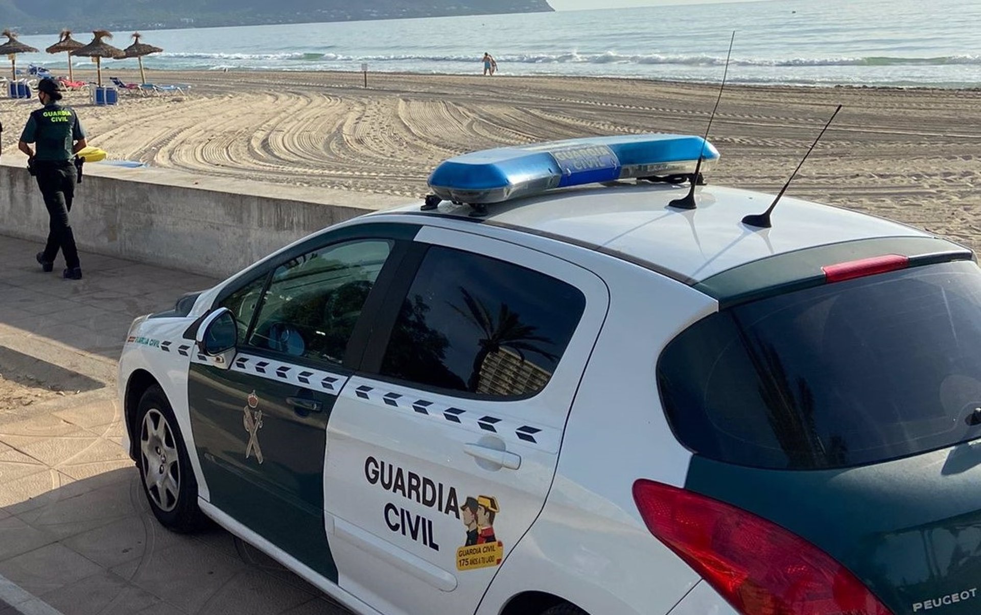 Una agente y un vehículo de la Guardia Civil en una playa de Mallorca. - GUARDIA CIVIL - Archivo