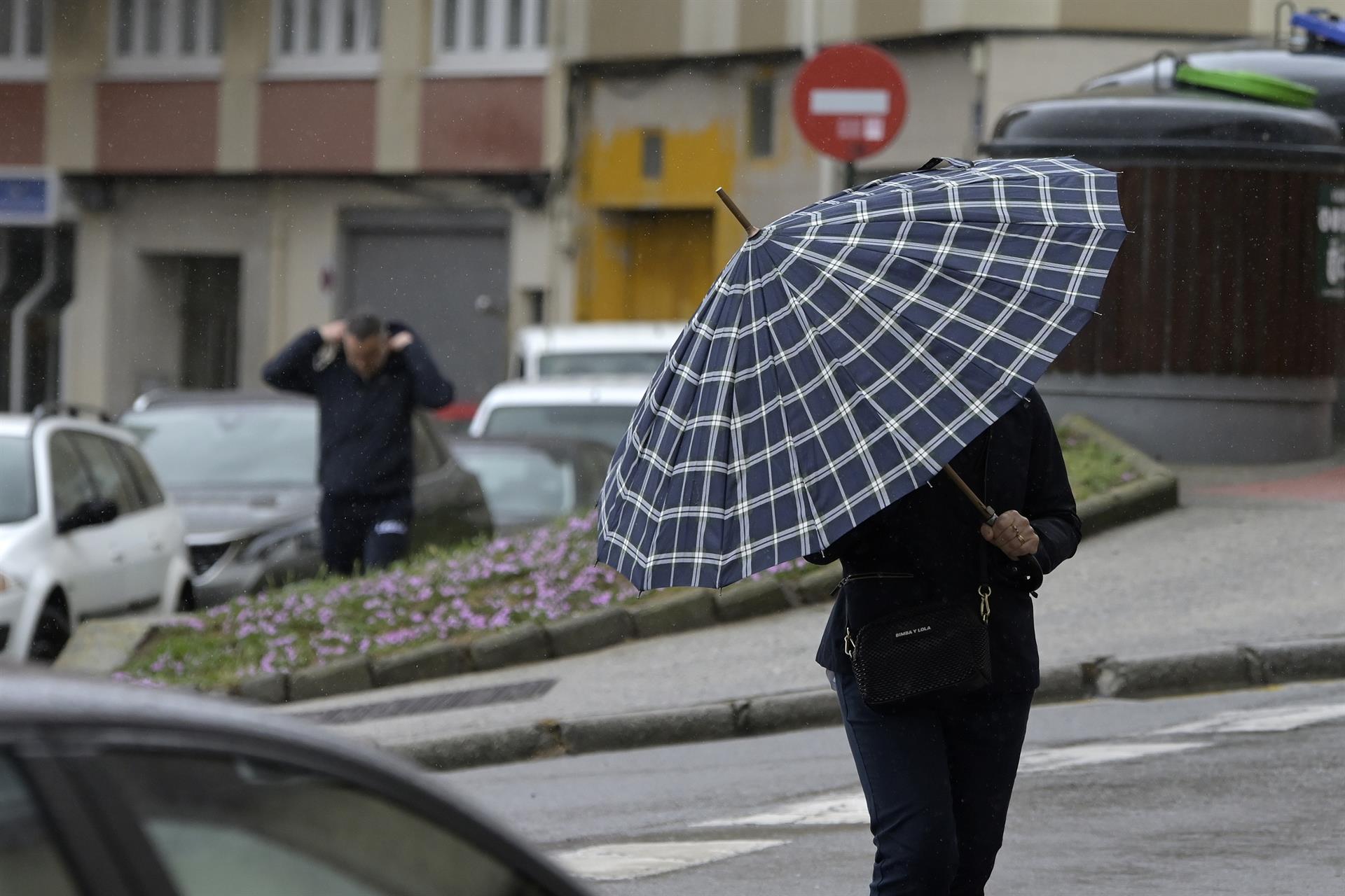 Una persona con paraguas camina por el centro de La Coruña, a 19 de junio de 2022, en A Coruña, Galicia, (España). La inestabilidad se mantendrá en Galicia al menos hasta la mitad de la semana que viene. A partir de mañana lunes 20 de junio el - M. Dylan - Europa Press - Archivo