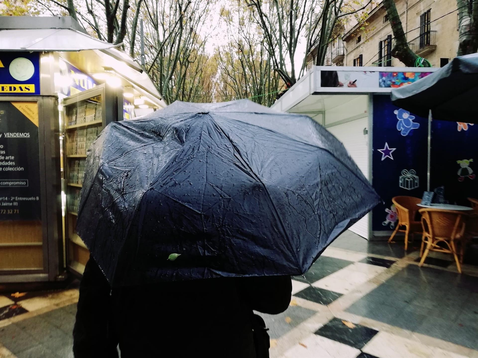 Un hombre pasea por la Rambla de Palma bajo un paraguas un día de lluvia. - EUROPA PRESS - Archivo