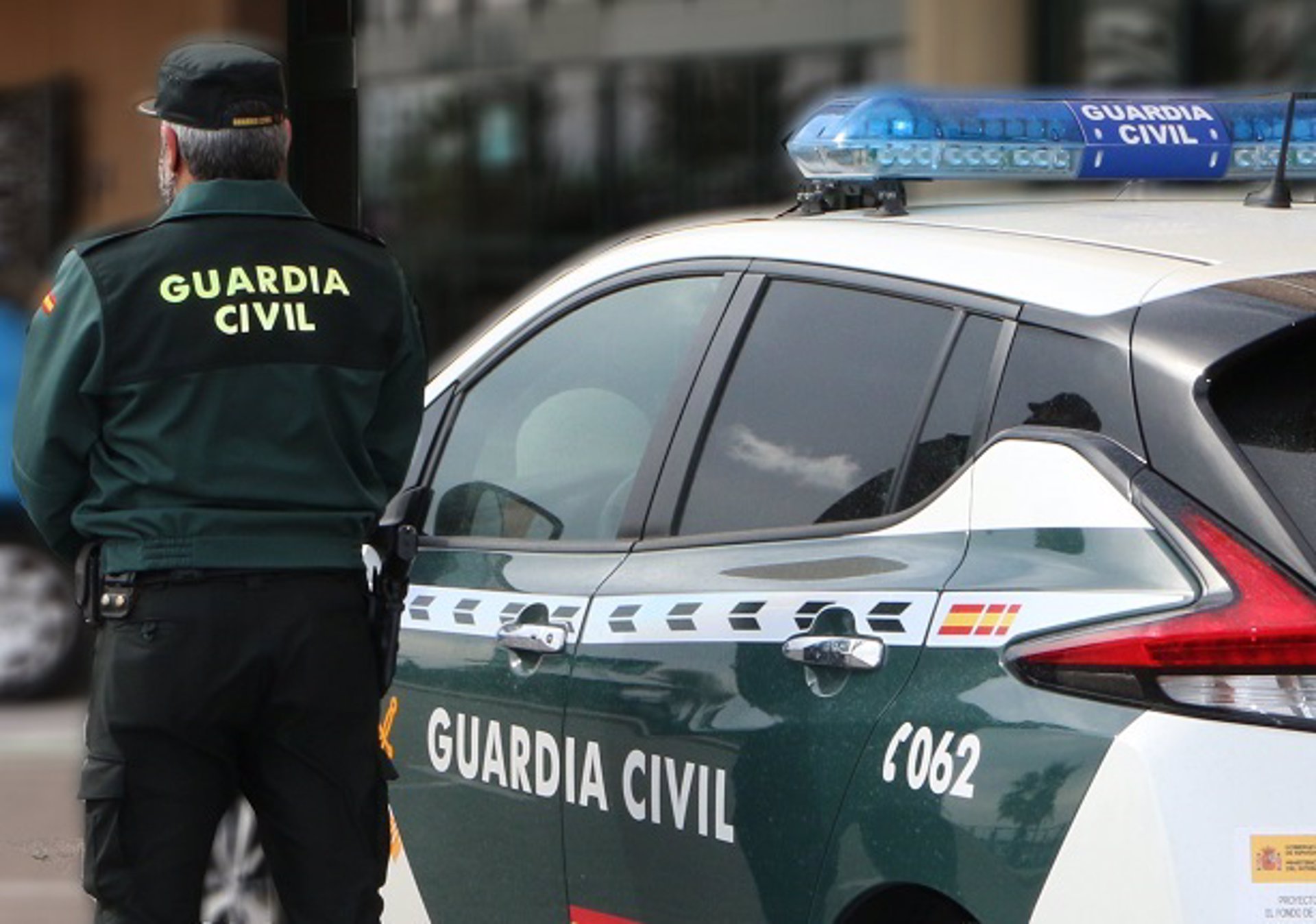 Un agente de la Guardia Civil junto a un vehículo del cuerpo. - GUARDIA CIVIL - Archivo