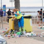 Una trabajadora de Emaya recogiendo residuos en el suelo, junto a unos contenedores, en el paseo junto a la playa, tras la noche de San Juan. - AYTO. DE PALMA