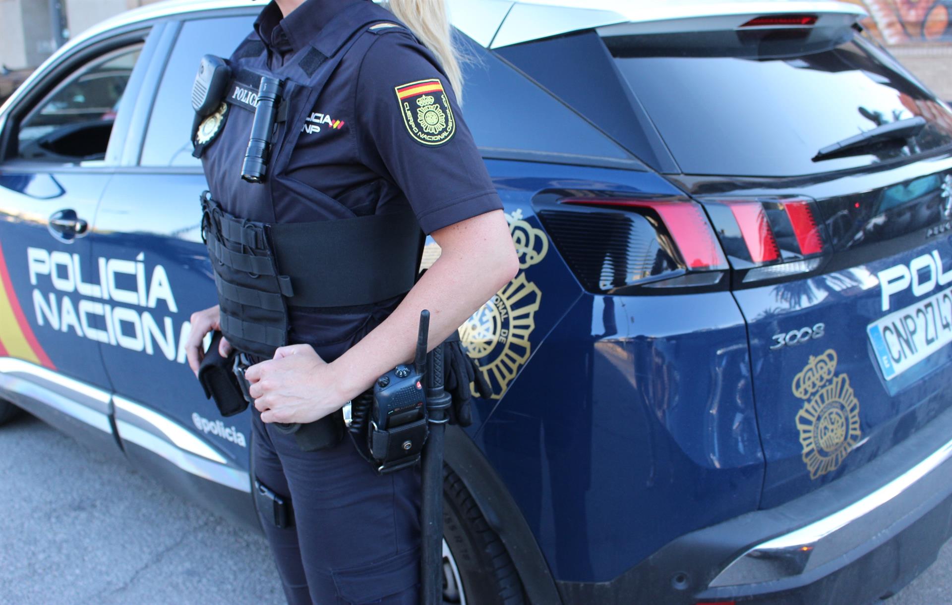Un agente y un vehículo de la Policía Nacional - POLICÍA NACIONAL