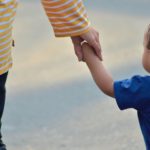 Niño acompañado de un mayor de edad.