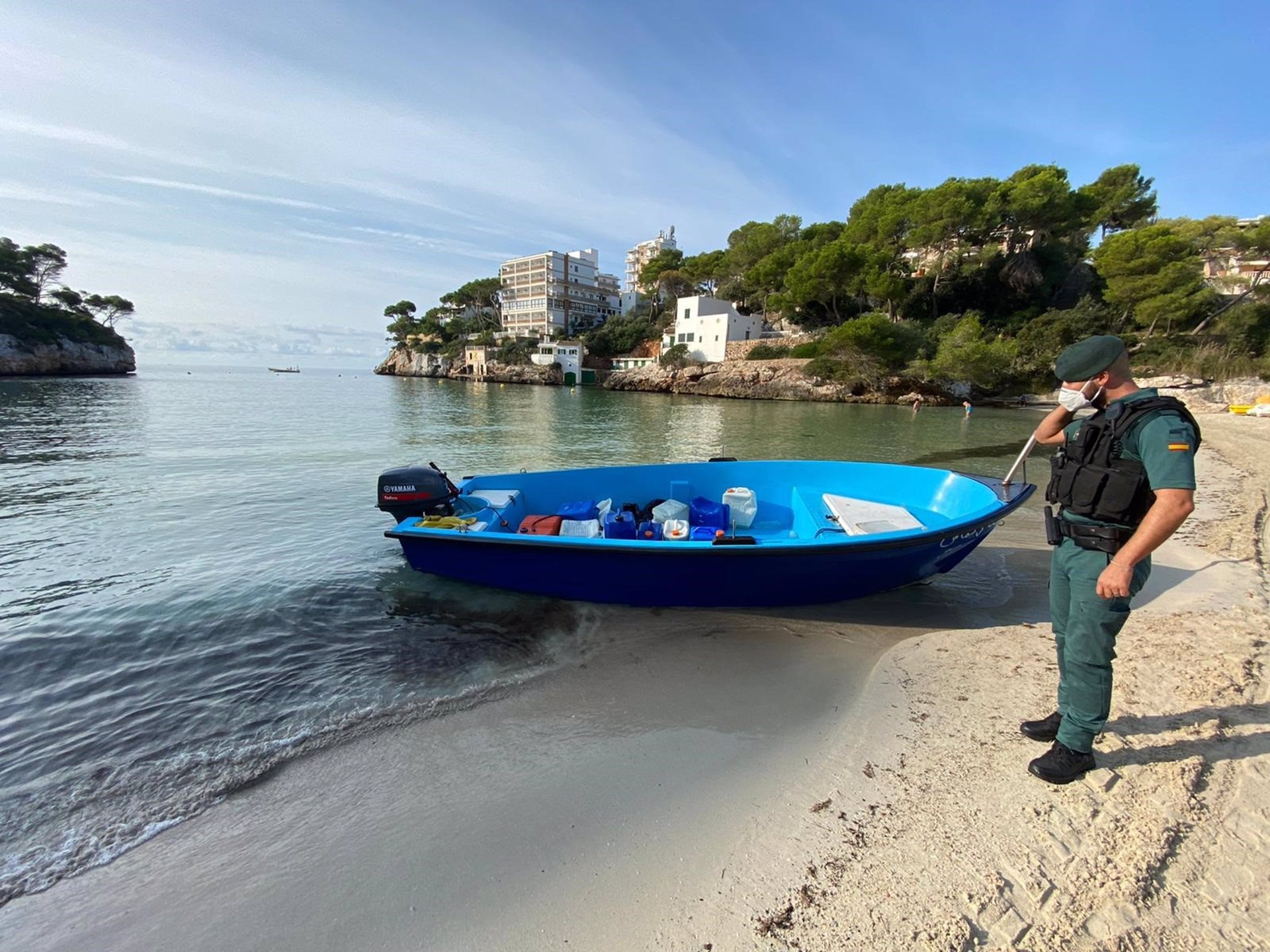 Un agente de la guardia civil, junto a una embaración, en una playa de Baleares. - GUARDIA CIVIL - Archivo