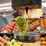 Un dependiente pesa un racimo de uvas en un mercado - Jesús Hellín - Europa Press - Archivo